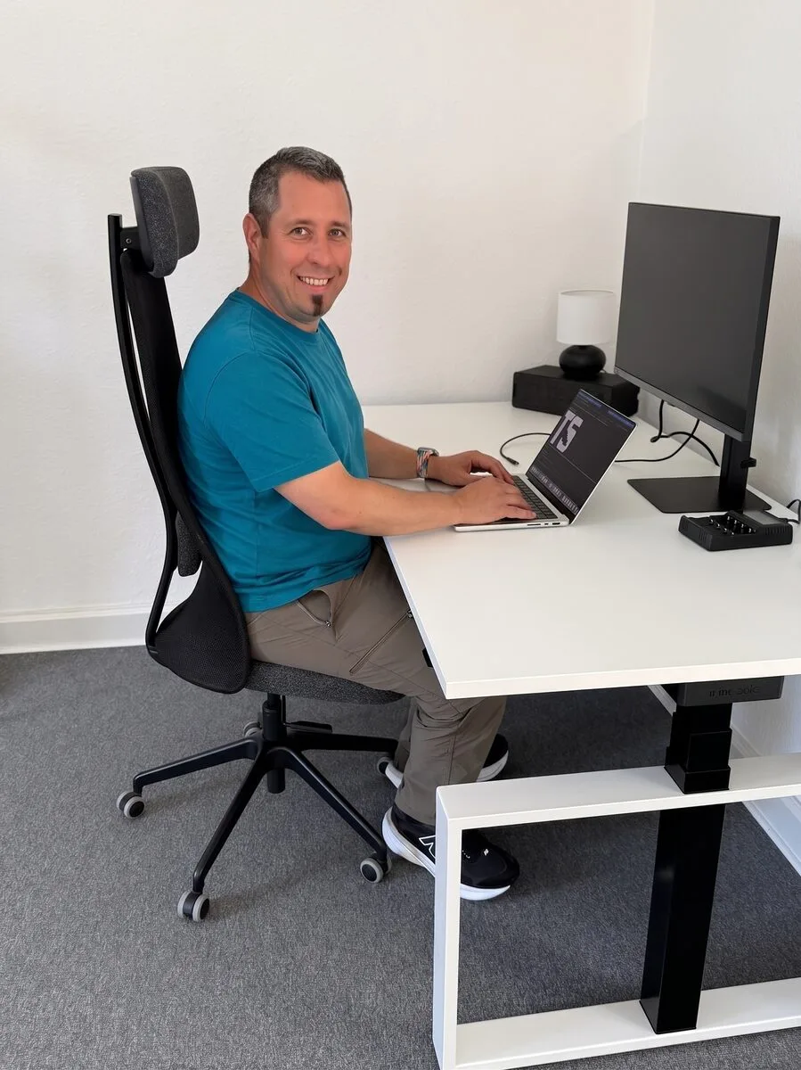 Tobias Schlitt am Schreibtisch mit Laptop